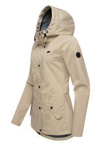 Beige waterproof jacket with a hood, front zipper and snap closure, two side pockets, elastic cuffs, and a black logo accent on the sleeve.
