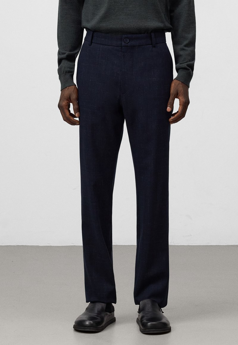 Pantaloni blu scuro realizzati in tessuto strutturato, caratterizzati da un design a gamba dritta, due tasche anteriori e una chiusura a bottone in vita.