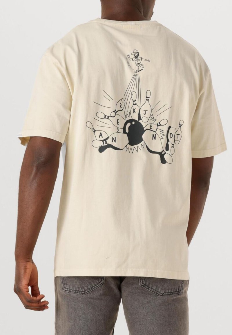 T-shirt di cotone crema con maniche corte, con una grafica nera sul retro che raffigura birilli da bowling e un personaggio in azione.