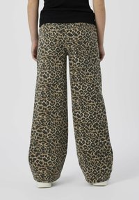 Byxor med vida ben i leopardmönster, med en blandning av beige och svart, med subtil struktur och standard bakfickor.