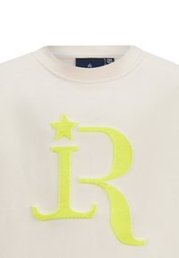 Felpa in cotone crema con un design testurizzato fluorescente giallo "R" e una stella sulla parte anteriore. Collo rotondo e maniche corte.