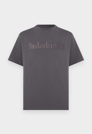 Sötétszürke, rövid ujjú, kerek nyakú póló, középen a mellrészen kiemelkedő Timberland logóval és fa emblémával.