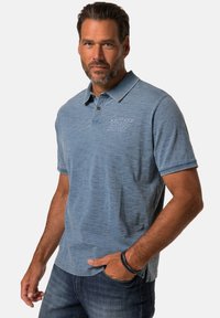 Modrá polo košile s krátkým rukávem, dvouknoflíkovou légou a vyšitým logem "Western Rodeo Supply" na levé hrudi.