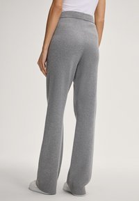 Grijze gebreide broek met een wijduitlopend ontwerp, elastische tailleband en geribde boorden. Zachte textuur en casual pasvorm, geschikt voor een relaxte look.