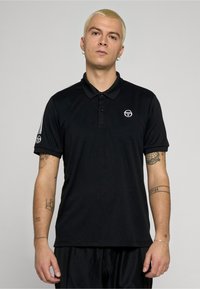 Czarna koszulka polo z gładkiej tkaniny, z kołnierzykiem zapinanym na guziki, krótkimi rękawami i białymi paskami na ramionach. Małe logo na piersi.