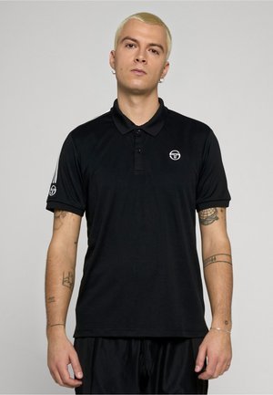 Polo nera in tessuto lucido, con collo abbottonato, maniche corte e strisce bianche a contrasto sulle spalle. Piccolo logo sul petto.