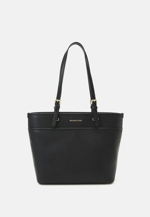 Sac cabas en cuir noir Michael Kors avec deux bretelles ajustables et des détails de boucle dorée sur fond blanc.