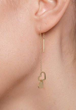 Gouden hartvormige oorbellen met een kettingontwerp. Bevat een hartvormige charm in omtrek en een massieve hartpendant die aan een delicate ketting hangt.