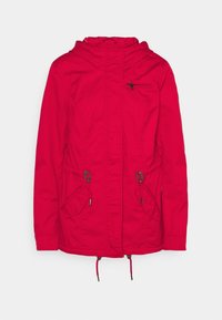 Veste à capuche rouge avec fermeture éclair sur le devant, deux poches à rabat sur les côtés avec œillets en métal, et une poche zippée sur la poitrine.