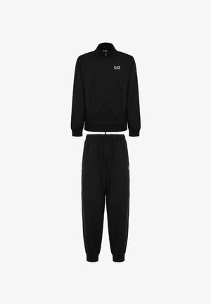 Il completo tuta nera include una giacca con zip frontale, colletto alto e polsini elastici, abbinata a pantaloni con cordino e orli a costine.