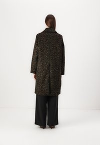 Manteau en imprimé léopard dans des tons de vert foncé et marron, avec un col cranté, des manches longues, une coupe décontractée et une longueur mi-mollet.
