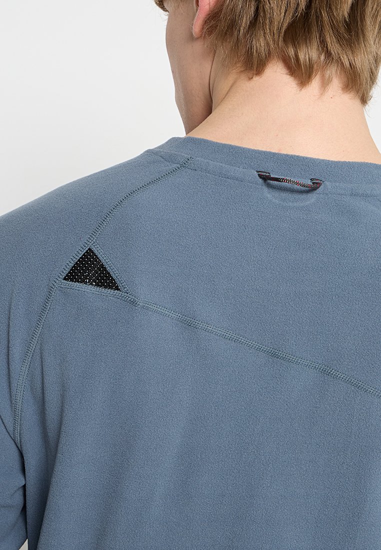 T-shirt technique bleu qui évacue l'humidité, avec un panneau en maille noire triangulaire au dos, des coutures à plat et une boucle au niveau du cou.