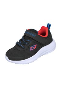 Zapato deportivo negro con parte superior de malla, acentos azules y forro rojo. Cuenta con una correa de Velcro y una suela de goma blanca con patrón texturizado.