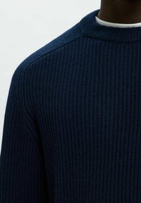 Navy svītrains džemperis ar augstu apkakli, izgatavots no struktūrfabric, ar horizontālām svītrām un nolaižamām plecu šuvēm.