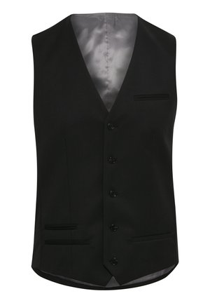 Homme vêtu d’un costume trois pièces noir avec une chemise blanche, une cravate noire et des chaussures de ville noires, debout devant un fond blanc uni.