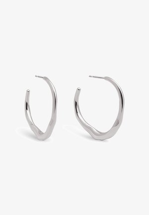 Boucles d'oreilles en argent avec un design torsadé. La texture est lisse, présentant une silhouette ouverte et une finition polie et réfléchissante.