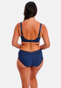 Marineblauw lingeriesetje met een gladde beha met verstelbare banden en een bijpassende high-waisted slip. Minimalistisch ontwerp met subtiele texturen.