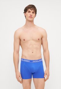Boxer in blu realizzati in un morbido tessuto elasticizzato con una cinta elastica spessa che presenta la scritta "JACK & JONES" in bianco.