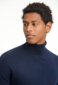 Navyblauer Rollkragenpullover aus strukturiertem Strickstoff, mit einem figurnahen Design und geripptem Kragen.
