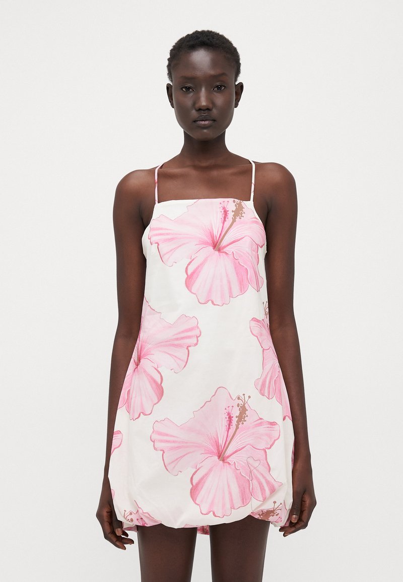 Vestido blanco con estampado de flores de hibisco rosa, tirantes delgados y ajustables, forma A, tejido ligero y corte relajado.