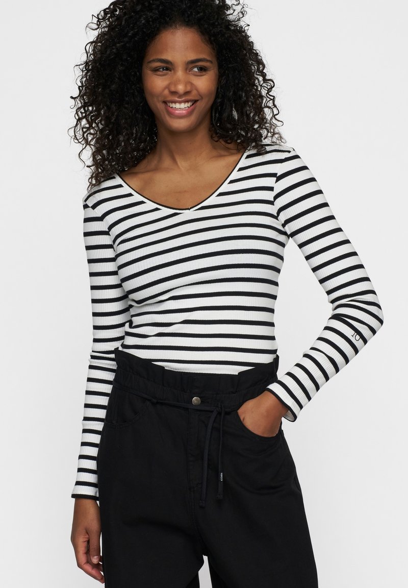 Zwart-wit gestreepte lange mouwen top, ribbelstructuur, V-hals ontwerp, gecombineerd met hoge zwarte broek met trekkoord tailleband.