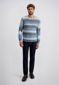 Lichtblauw en grijs gestreepte gebreide trui met een ronde hals, geribde manchetten en onderrand, gecombineerd met een donkere spijkerbroek en bruine instapschoenen.