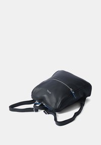 Zaino in pelle nera con forma affusolata, chiusura superiore con zip, spallacci regolabili e dettagli blu. Texture liscia con branding minimale.