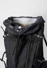 Fekete nylon hátizsák, felgörgethető záródással, szürke béléssel, állítható pántokkal és külső hevederekkel a további tárolási lehetőségek érdekében.