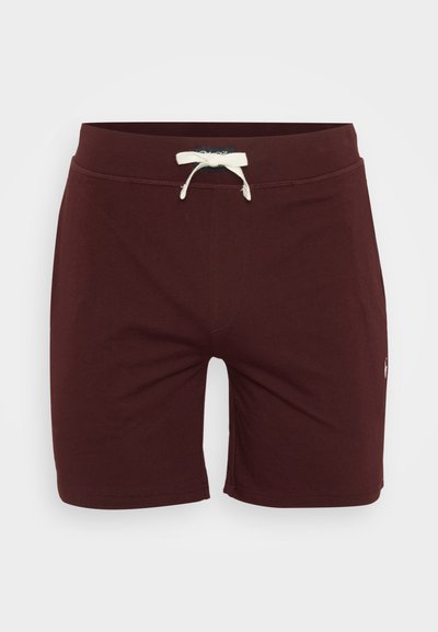 Calções de banho em cor bordeaux feitos de tecido suave, com um cós ajustável e um pequeno detalhe de logótipo na parte inferior da perna. Design simples e ajustado.