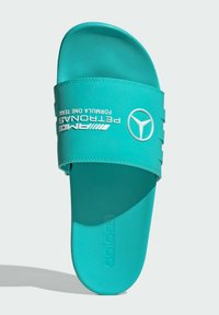Turkist slide sandal med tekstureret overdel, der har hvid branding og et Mercedes-Benz logo. Flad sål designet til komfort.