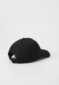 Sort baseballcap med en buet skygge, justerbart bånd på bagsiden og tekstiloverflade med ventilationshuller på siderne.
