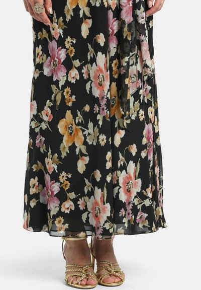 Black floral midi skirt with pink, orange, and white flowers worn with gold braided strap open-toe heels and a large decorative ring on left hand.