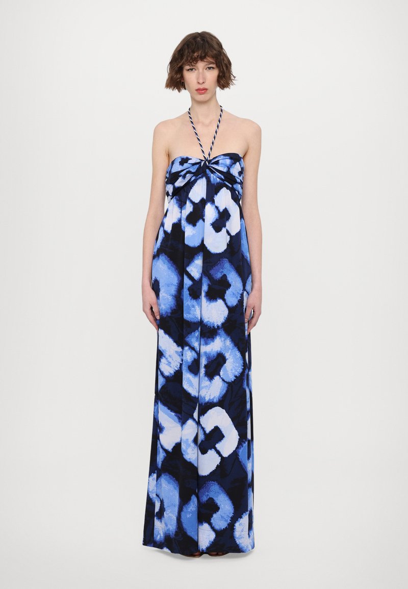 Robe maxi avec un col halter dans un motif abstrait bleu et noir, présentant un détail noué à l'avant et un tissu fluide et léger.