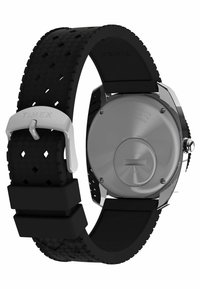 Bracelet de montre en caoutchouc noir avec un design texturé, boucle en métal argenté et fond de boîtier en acier inoxydable présentant une gravure de la marque.