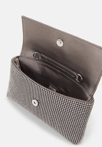Pochette argentée avec un extérieur en strass texturé, une fermeture à pression et une doublure en tissu lisse avec une poche intérieure.