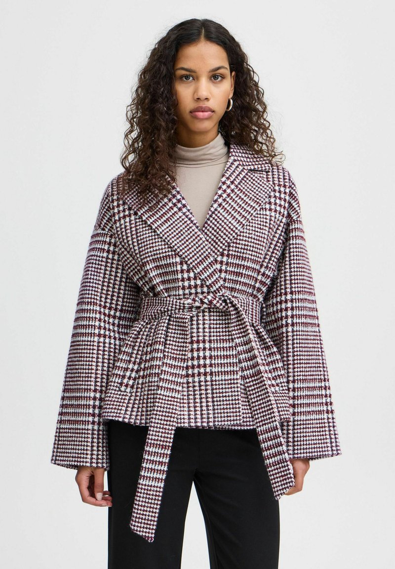 Cappotto avvolgente a scacchi con maniche larghe, vita regolabile con cintura, caratterizzato da un motivo nei colori bordeaux, bianco e navy, realizzato in tessuto testurizzato.