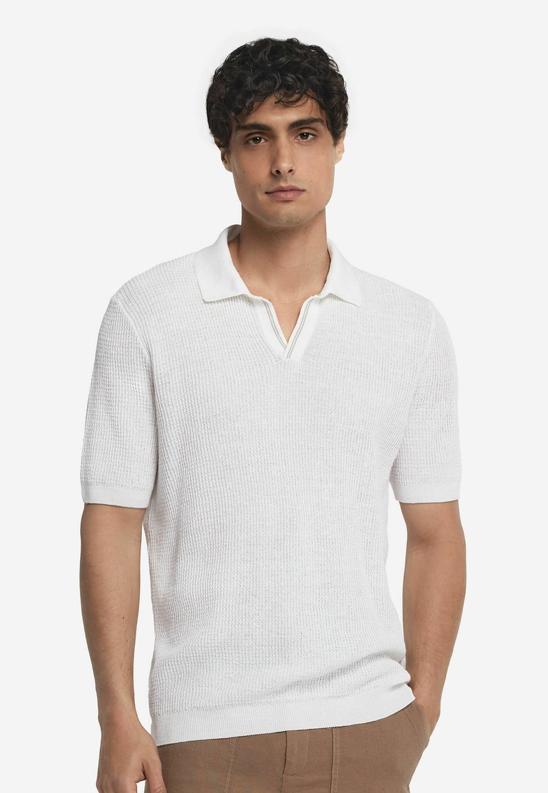 Polo blanc à manches courtes avec un design en maille texturée et un col en V peu profond. Il présente un col blanc contrastant et des poignets côtelés.