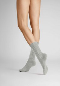 Graue gestrickte Socken mit einem gerippten Bündchen und einem Zopfmuster, die für Komfort und Wärme entworfen wurden.