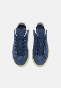 Marina mocka sneakers med vita detaljer, platta snören och en texturerad tunga. Har en gummisula och broderad logodetalj.