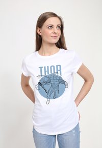 Bílé tričko s krátkým rukávem s modrou grafikou svalnaté postavy s sekyrkou a textem "THOR" nad ní. Jednoduchý kruhový design.