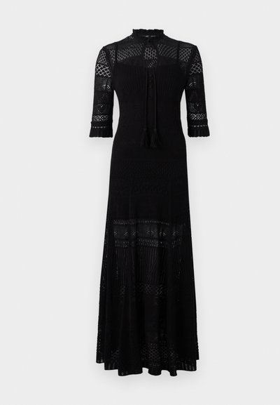 Abito maxi nero con collo alto, intricate decorazioni in pizzo, maniche a tre quarti e fiocchi a frange. Caratterizzato da un tessuto texture e orlo a strati.