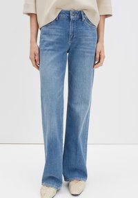 Lichtblauwe jeans met hoge taille en rechte pijpen. Gemaakt van denim met een gladde textuur; voorzien van standaardzakken en een knoopsluiting aan de voorkant.