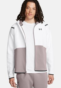 Hoodie mit Reißverschluss in Weiß und hellem Lila, mit einer strukturierten Oberfläche. Ausgestattet mit einem schwarzen Reißverschluss und Akzenten, kombiniert mit einem weißen T-Shirt.