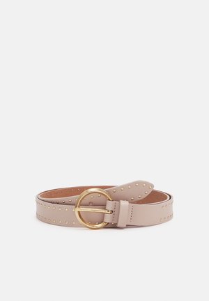 Licht beige leren riem met kleine gouden studs en ronde gouden gesp, plat opgerold op een witte achtergrond.