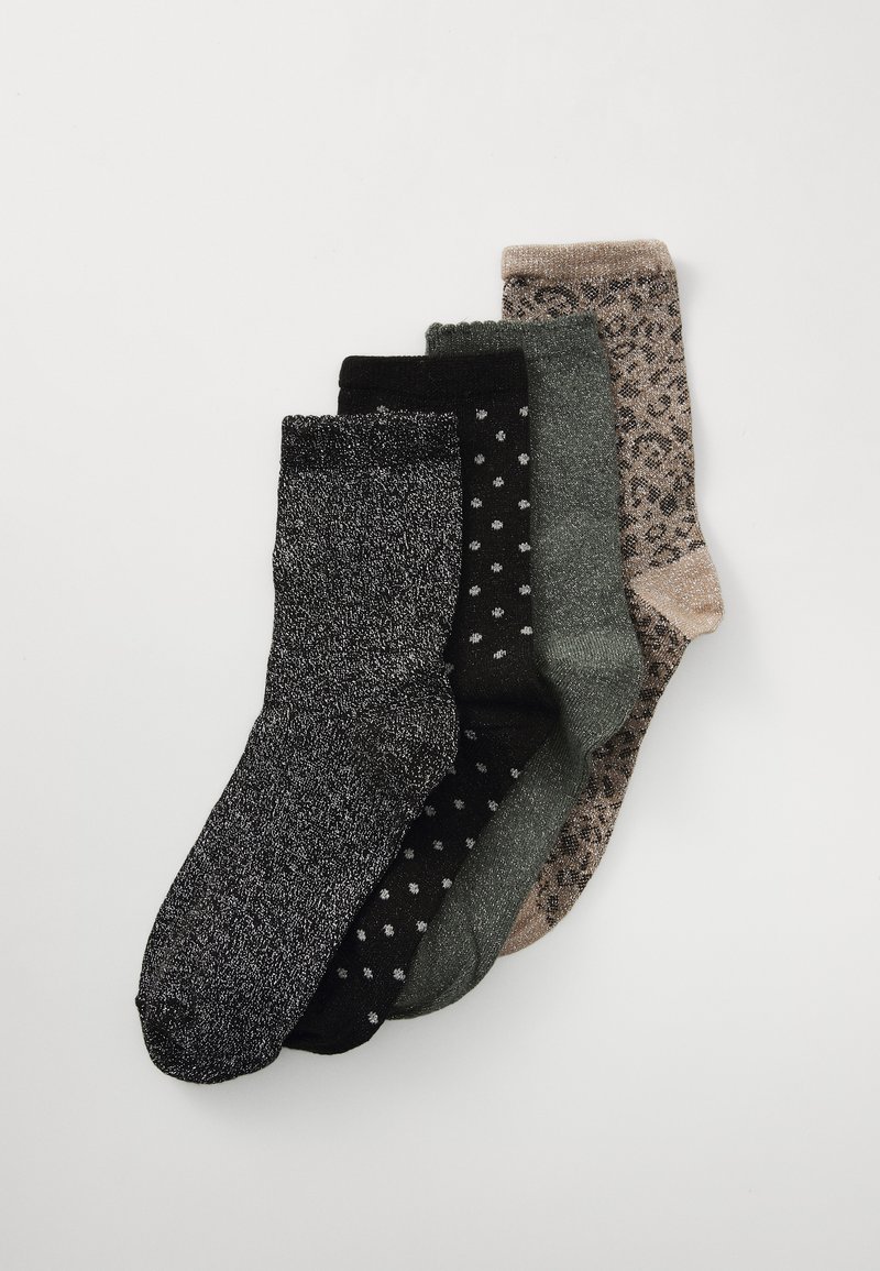 Cuatro pares de calcetines: uno negro con brillos, uno negro sólido con lunares blancos, uno verde oscuro y uno beige con un patrón de leopardo.