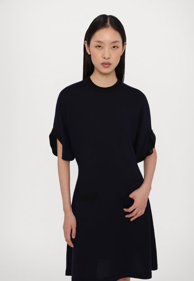 Robe tricotée bleu marine à manches courtes, col rond, avec poches latérales et accents de boutons sur les manches. Texture lisse et coupe décontractée.