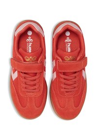 Czerwone buty sportowe z tekstylnymi i zamszowymi cholewkami, białe boczne paski, gumowe podeszwy oraz rzep na wierzchu.