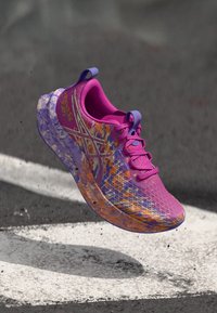 Ελαφρύ αθλητικό παπούτσι σε ζωηρό ροζ, βιολετί και πορτοκαλί χρώμα. Διαθέτει επάνω μέρος από αναπνεύσιμο δίχτυ, υφή στη σόλα και διακοσμητικές λεπτομέρειες.