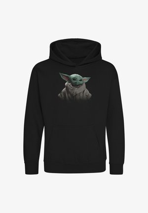 Hoodie noir avec un graphique d'un personnage vert aux grandes oreilles, portant une robe et une écharpe beiges, centré sur le devant.