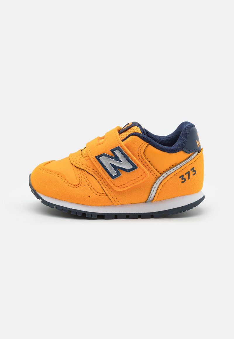 Baskets pour tout-petit orange vif avec des accents bleu marine, fermeture velcro, semelle blanche et logo "N" sur le côté, numéro de modèle 373 au talon.